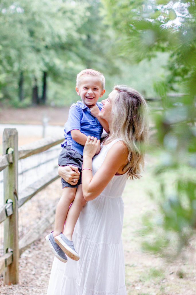 A mom hugging her son in a park in Greenville SC during a family and maternity session by Jenny Macy Photography.
