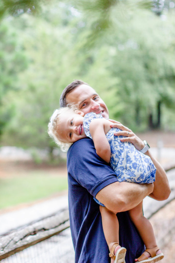 A father hugging his daughter in a park in Greenville SC during a family and maternity session by Jenny Macy Photography.