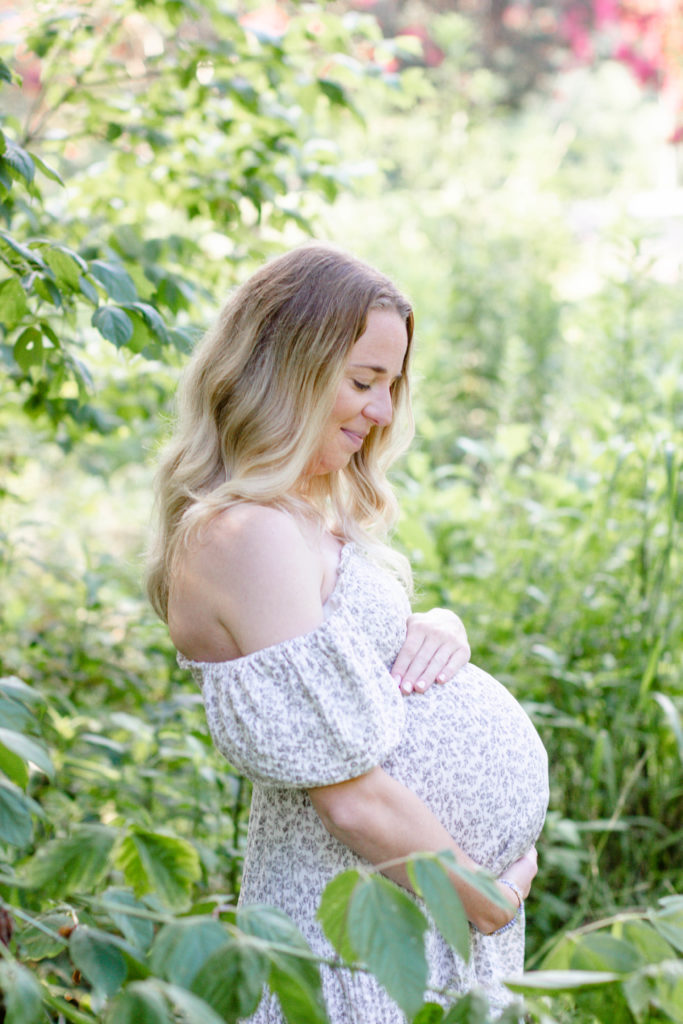 A mom holding her tummy during maternity mini session in Greenville, SC by Jenny Macy Photography.