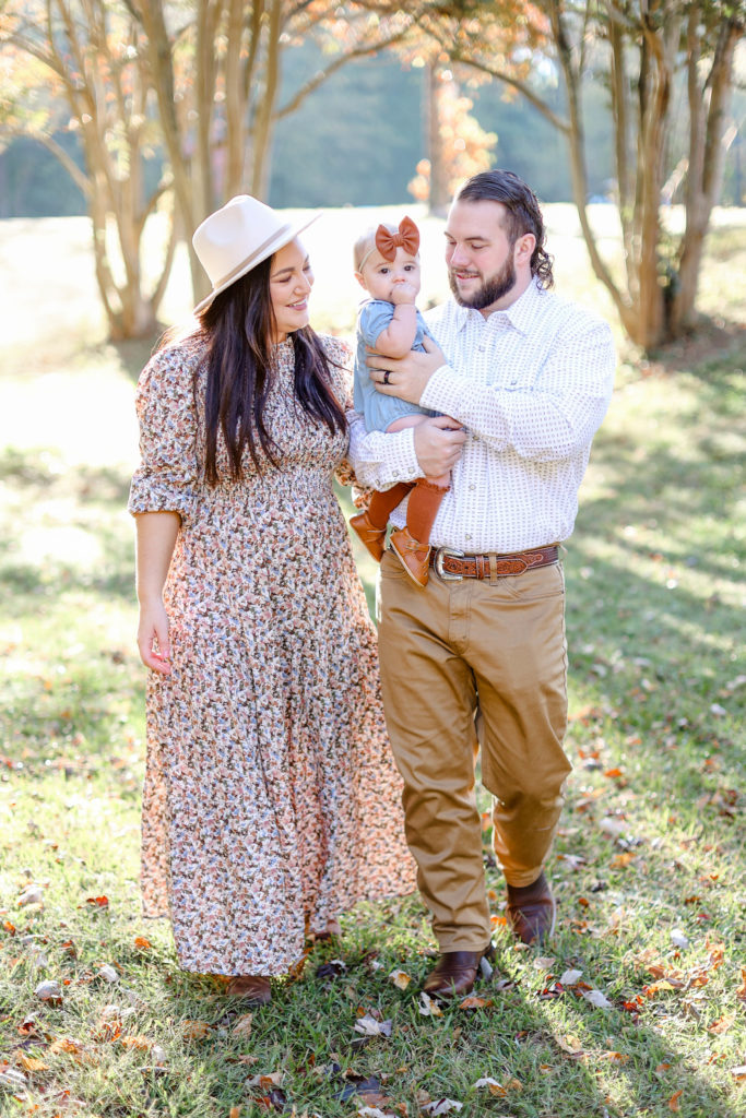 A family of 3 walking during a Greenville, SC fall mini session with Jenny Macy Photography.