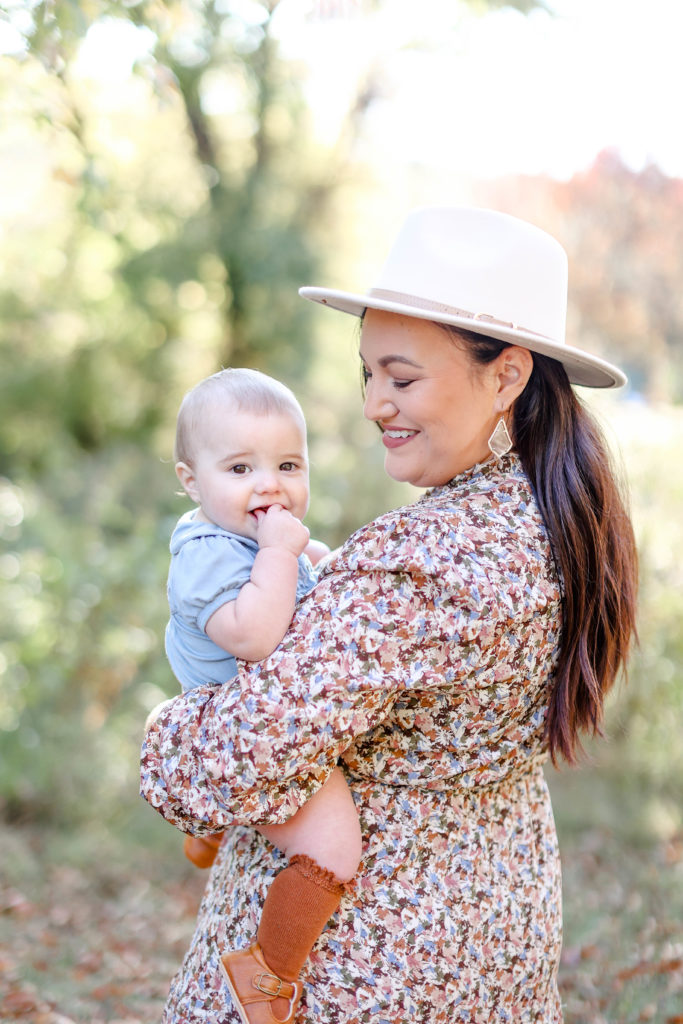 A mother in a hat holding her daughter during a Greenville, SC fall mini session with Jenny Macy Photography.