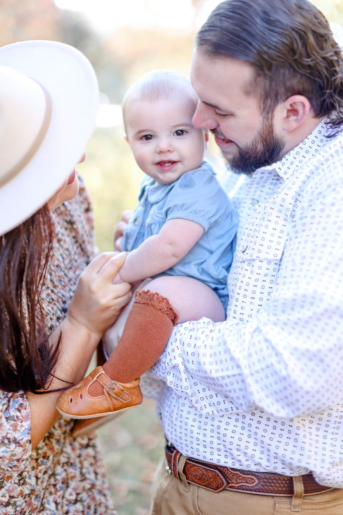 A family cuddling their baby girl during a Greenville, SC fall mini session with Jenny Macy Photography.